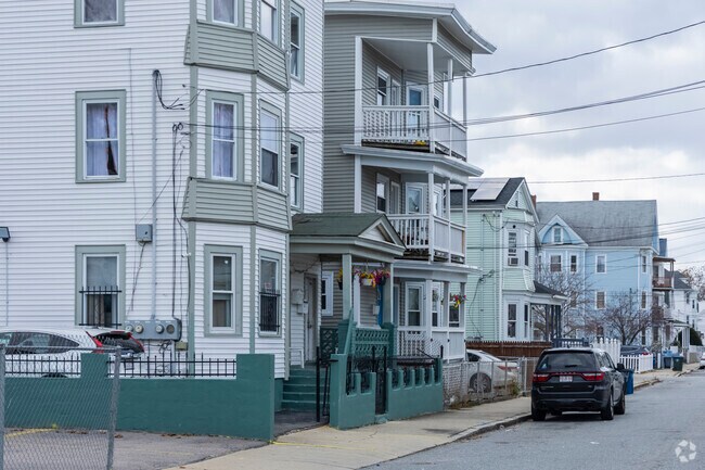 A row of classic triple-decker homes in Lawrence showcases timeless urban New England charm.