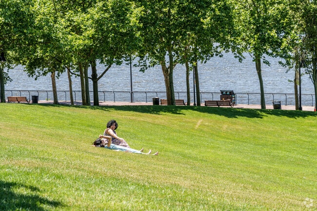 Two women enjoy some time relaxing on the lawn at the Central Waterfront's Wiggins Park.