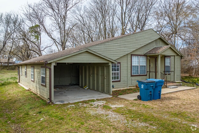 A unique, wooden Gravette home stands out from its neighbors.
