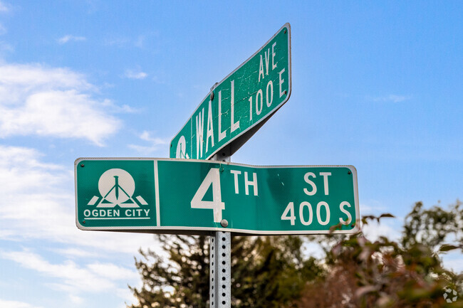 A green street sign at Wall and 4th Street.