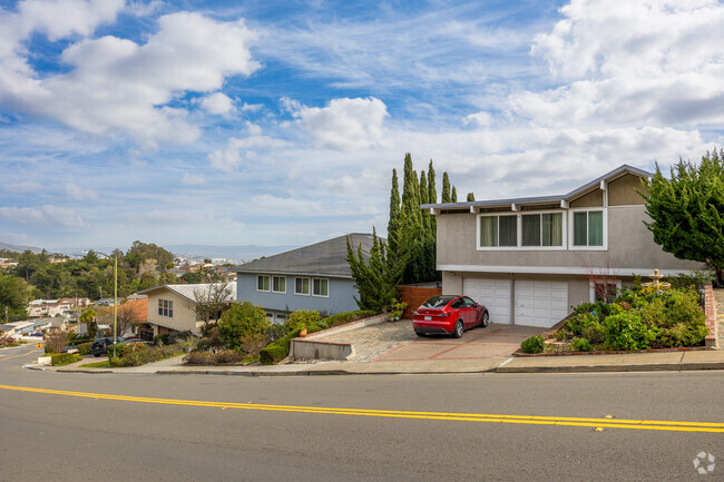 This split-level home in Millbrae Meadows offers a hillside view and a well-maintained garden.