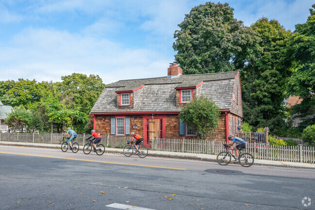 Cyclists pass a Cape Cod home that was constructed in 1744 in Telegraph Hill.