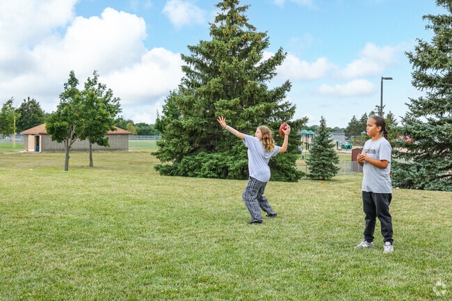 Expansive green spaces at Kenny Anderson Park invite games and recreation.