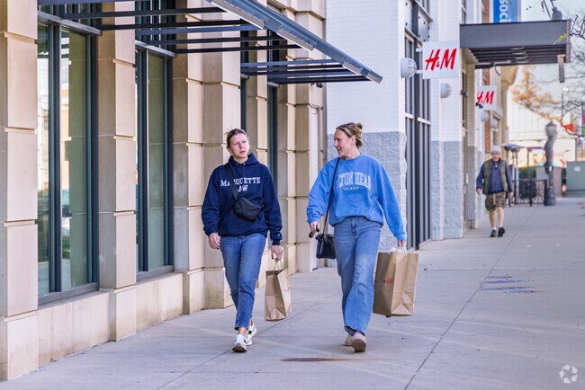 Shoppers stroll past retail stores near Kletzsch neighborhoods.