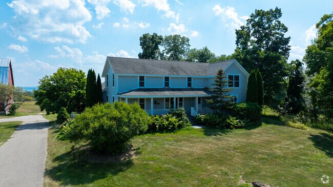 Green lawns and bay views surround a historic home on Michigan’s wine-producing peninsula.