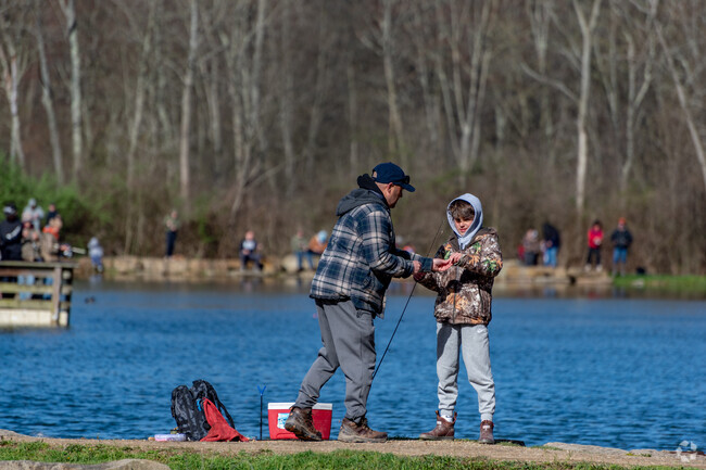 Parents helping their children fix and bait a hook at the Kids' Fishing Derby