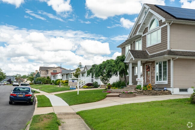 Row of homes lined by sidewalks and freshly cut grass.