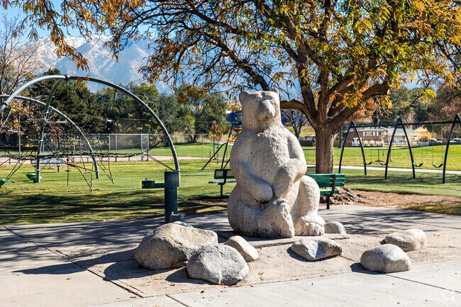 Stones surround a large bear carved from stone at Big Bear Park.