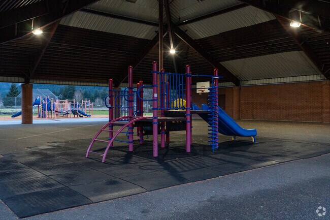 A covered play structure sits behind the school.