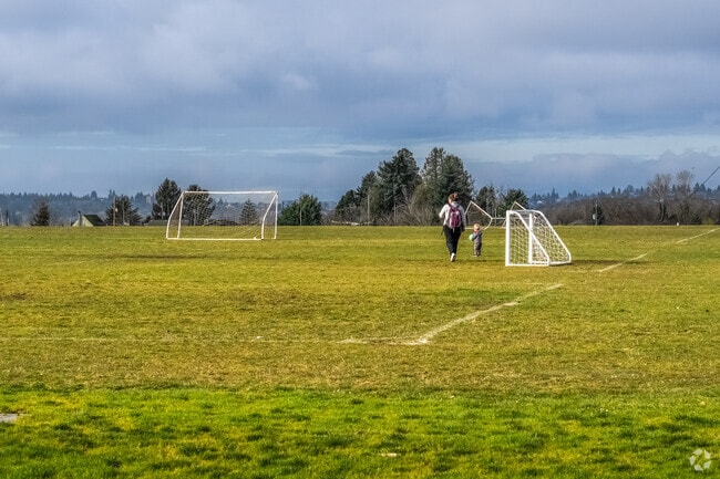 North Beacon Hill mom and child playing on a sports field in the early morning.
