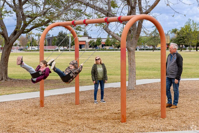 Kids enjoy the swings at Liberty Park in Bakersfield.