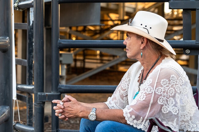 A woman wears a lacy top and white cowboy hat at Utah State Fairpark.