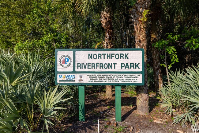Northfork Riverfront Park sign framed by trees in Dorsey Riverbend.
