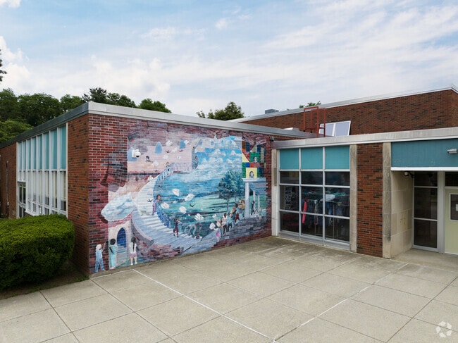 A mural of books in flight and the diversity of Mill Road Primary in Rhinebeck.