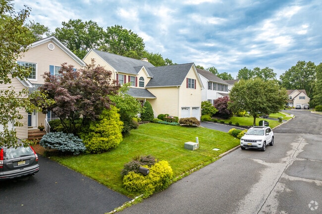 Suburban homes with manicured front lawns contour a residential street in Bridgewater, NJ.