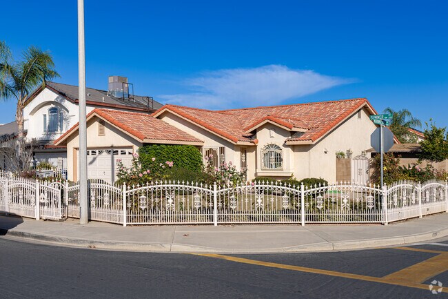 A white decorative iron fence adds character to this Spanish style corner home in East Delano.