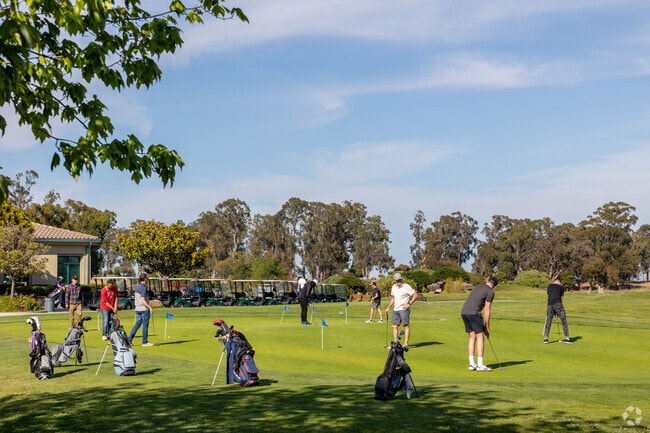 Golfers practicing their chip game at Poplar Creek Golf Course near Oak Grove Manor.