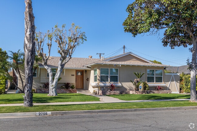 A traditional Ranch-style home with lush green grass and mature trees can be found in Anaheim.