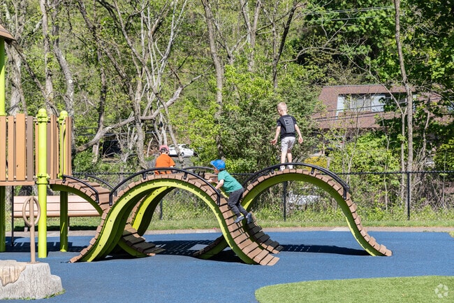 Kids climb and play with friends at the playground at White Oak Park.