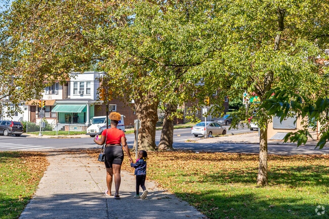 Residents walk under the shade of the oaks in Connell Park in Paschall.