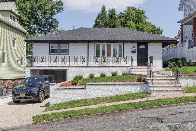 A brick split level takes advantage of the sloping hill to have a basement garage.