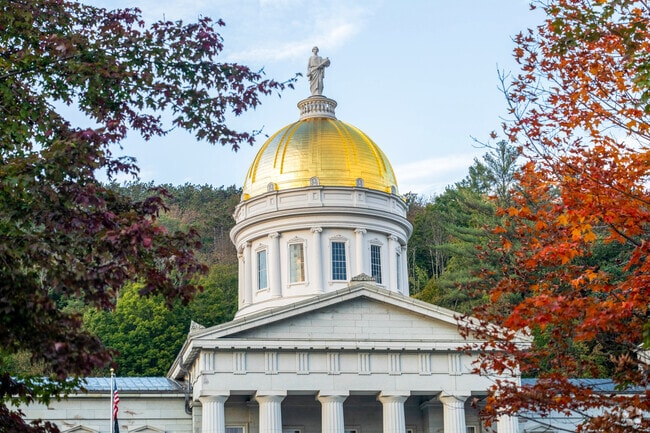 The Vermont Capitol dome peaks through the turning leaves near Berlin Street.