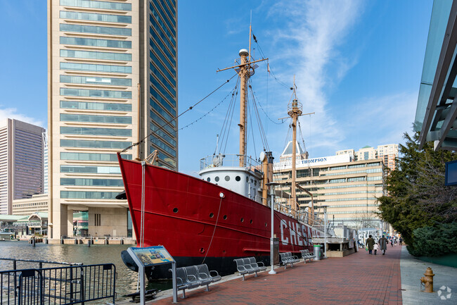 Historic boats line Downtown Baltimore's inner harbor for people to explore.