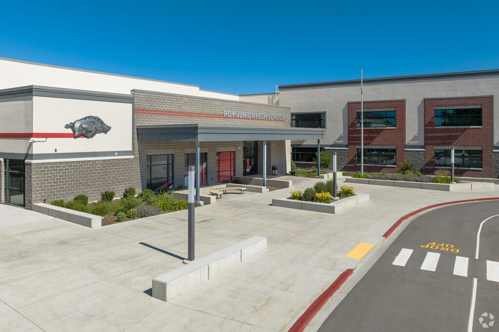 A gray brick entrance with a red stripe at Roy Junior High School.