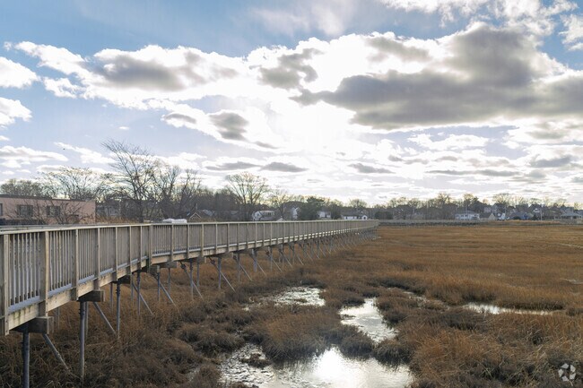 Locals can walk through the Nerio pathway as they enjoy the sunset falling on Belle Isle Marsh Marine Ecology Park.