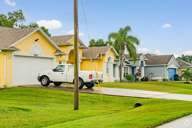 Colorful single-family homes in Saint Lucie North sit on palm-lined streets.