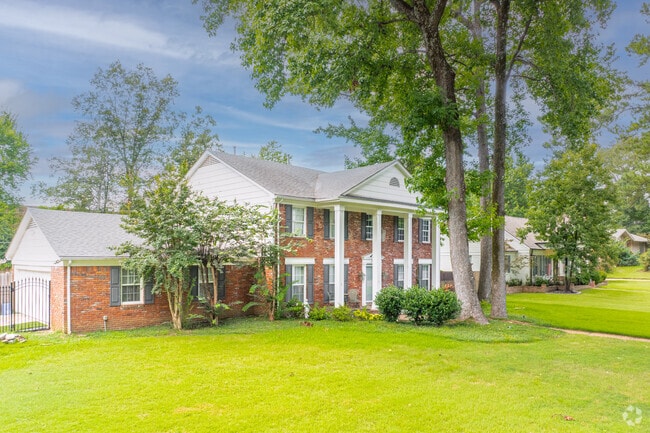 A picturesque River Oaks Colonial home with pedimented entry and tree-lined yard captures Southern residential beauty.