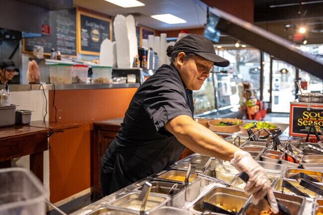 A worker attends to the salad bar at Summit's popular deli and butcher, The Meat House.