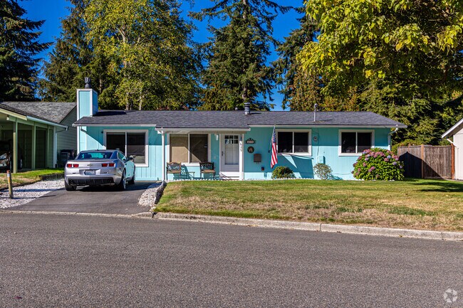 This stunning ranch home has a bright green exterior and perfect lawn.