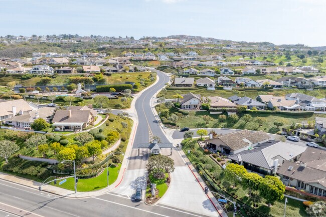 An aerial view of Broadmoor Sea View reveals a picturesque coastal neighborhood with elegant homes, lush landscapes, and sweeping ocean views, nestled in the heart of Newport Beach.