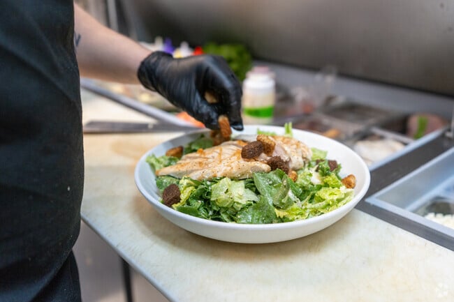 A chef at Northside Grille in Litchfield prepares a chicken caesar salad.