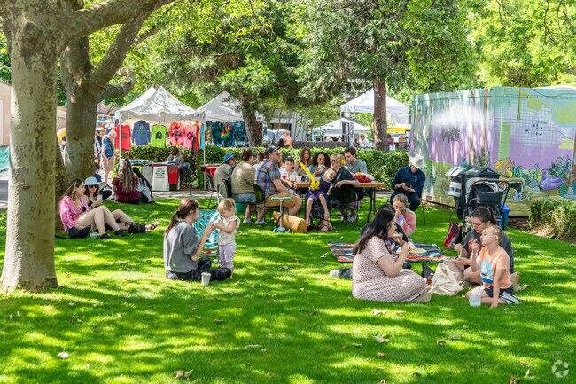 Families enjoy picnics under the shade at the Eugene Saturday Market in Downtown Eugene.
