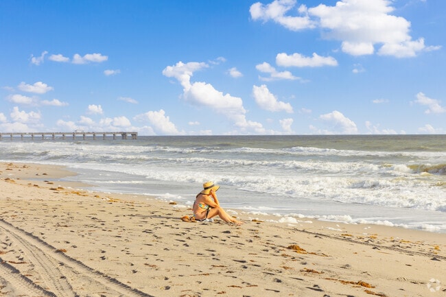 A woman enjoys scenic ocean views at Juno Beach only a few miles from Evergrene.